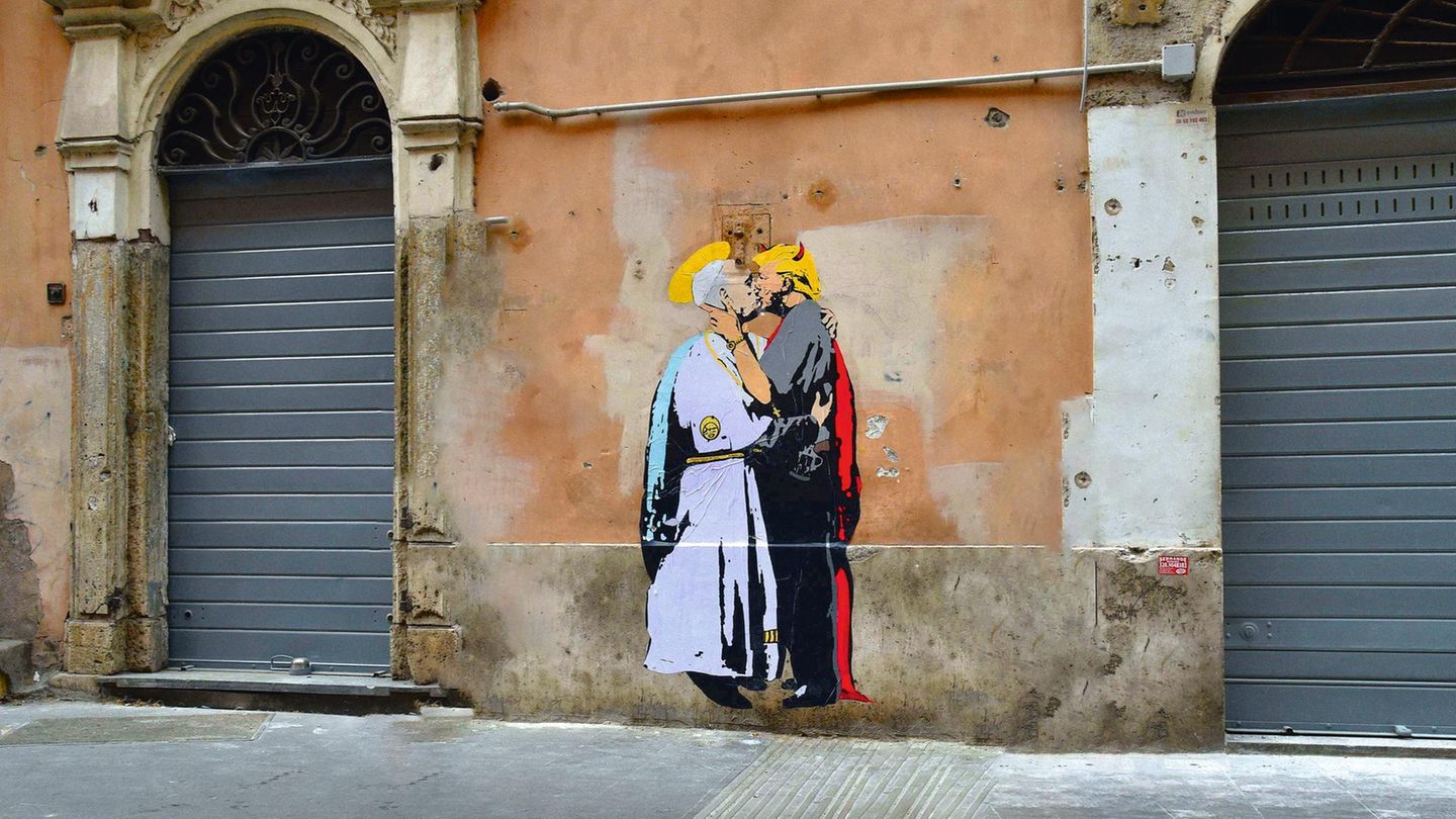 Der Pabst und Donald Trump küssen sich auf einem Graffiti