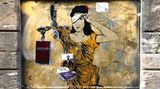 Ein Graffiti von Justitia Sie hebt eine Seite der Augenbinde