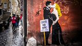 Ein Graffiti von einem Paar, dass sich küsst mit Atemmasken
