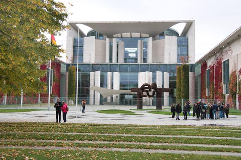 Menschen stehen vor dem Kanzleramt in Berlin