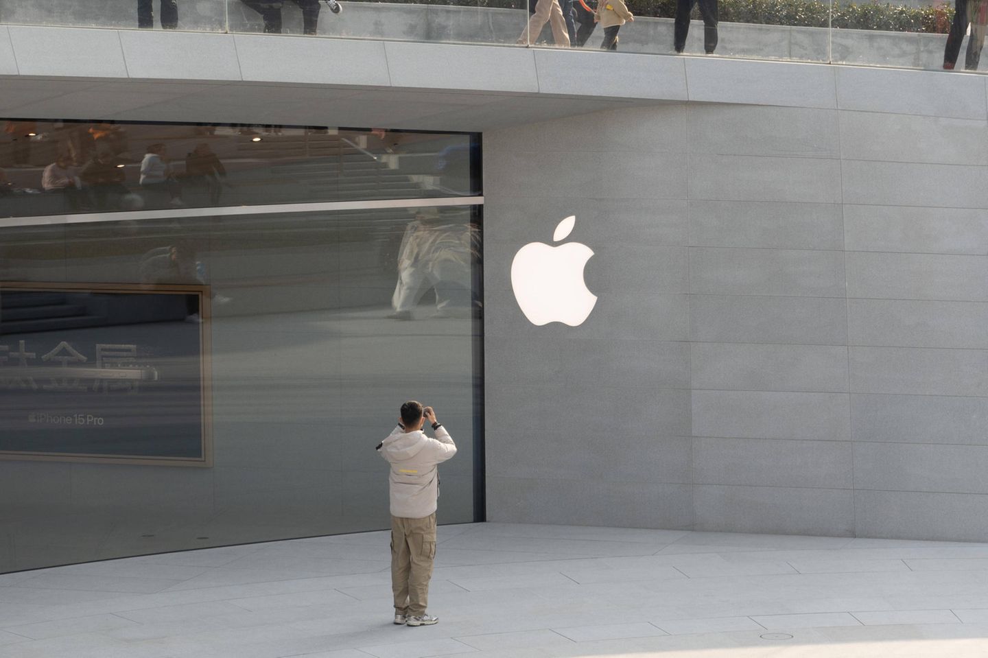 Mann fotografiert Apple-Logo