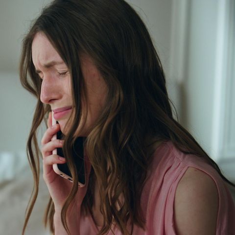 Eine Frau weint am Telefon