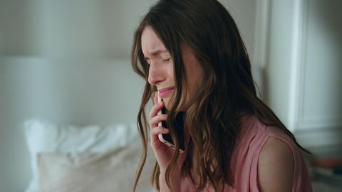 Eine Frau weint am Telefon