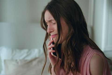Eine Frau weint am Telefon