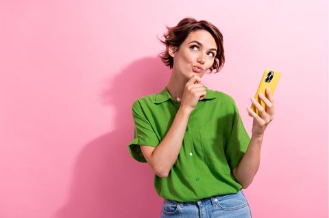 Frau mit iPhone 15 Pro Max guckt nachdenklich