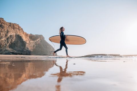 Surferin auf dem Weg zum Meer