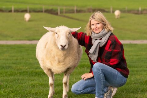 Anne Hansen mit Lämmchen am Deich
