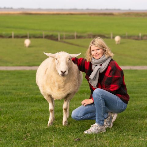 Anne Hansen mit Lämmchen am Deich