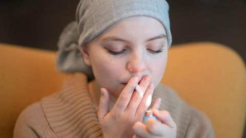 Ein Mädchen mit einem Kopftuch raucht gegen eine Chronische Krankheit einen Cannabis Joint