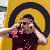 Diesen Nazi kennen inzwischen viele Menschen. Es ist der österreichische Identitäre Martin Sellner, Zentralfigur des Potsdamer Geheimtreffens, wo er seine rassistischen Vertreibungsphantasien vorstellte. Hier posiert er vor dem markigen Logo der "Identitären Bewegung", als deren Kopf er gilt. Das Symbol der Identitären soll auf den griechischen Buchstaben Lamda anspielen, wirkt aber dann doch eher wie eine Nazi-Rune als wie ein antiker Buchstabe. Auf diesem Bild scheint der modisch sonst eher unverfängliche Sellner eine provokative Gratwanderung zu wagen. Der Aufnäher auf seinem T-Shirt im identitären Weinrot soll wohl auf das Emblem der völkischen Vereinigung "Artgemeinschaft – Germanische Glaubens-Gemeinschaft wesensgemäßer Lebensgestaltung" anspielen, das einen Adler beim Fischfang zeigt. 2023 verbot Bundesinnenministerin Nancy Faeser die Organisation, weil sie völkisch-rassistisches, revisionistisches und antisemitisches Gedankengut vertrat. Natürlich wird Sellner zu seiner Verteidigung sagen: "Aber da ist doch gar kein Fisch zu sehen. Das ist doch einfach nur ein Adler." Aber so funktioniert eben das Spiel mit heimlichen Codes und Anspielungen: erst andeuten, dann abstreiten. Die Eingeweihten werden schon Bescheid wissen.