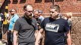 Links auf dem Bild sehen wir wieder einen Nipster: Designer-Bart und dicke Kastenbrille. Der Styler könnte auch in einem angesagten Social Startup im Prenzlauer Berg PR-Kampagnen für Seenotrettung entwerfen. Das wird er aber ganz sicher nicht tun. Denn es handelt sich bei dem Nazi-Hipster um den Identitären Robert Timm, der sich vor allem vor Überfremdung in Europa durch Migranten fürchtet. Diese völkische Kümmernis bringt er hier 2019 auf einer Demo der "Identitären Bewegung" in Sachsen-Anhalt  zum Ausdruck. Dieselben Überfremdungsängste thematisiert auch sein Identitären-Kamerad Daniel Fiss rechts neben ihm unter Zurhilfenahme seines T-Shirt-Aufdruckes. Als stilbewusster Nipster trägt Timm allerdings keine Motiv-Shirts, sondern ein Polohemd von Fred Perry. Die Marke wurde bei Rechtsextremen vor allem wegen ihres Logos beliebt, das einen stilisierten Siegerkranz zeigt, der Rechtsextremen auf der ganzen Welt wohl irgendwie genuin faschistisch zu sein scheint. In den USA wählten die rechtsextremen "Proud Boys" die Hemden von Fred Perry sogar als ihre offizielle Uniform aus. Viele davon erstürmten darin 2021 das Kapitol in Washington. Erfreulicherweise erwarteten sie dann keine Lorbeerkränze, sondern saftige Haftstrafen.
