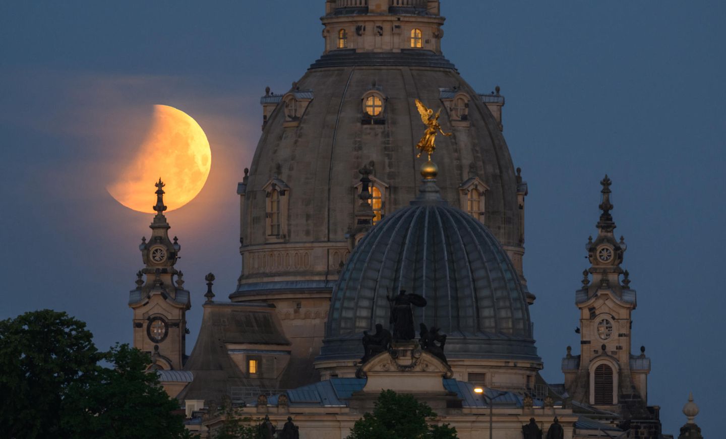 Roter Mond steht über der Dresdener Frauenkirche sowie über der Kuppel der  Kunstakademie