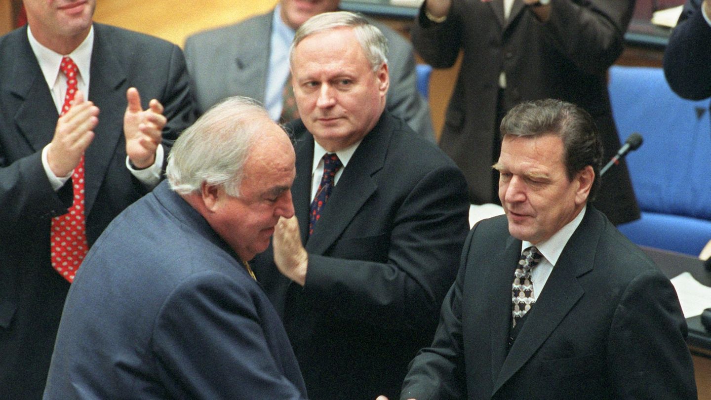 Helmut Kohl schüttelt Gerhard Schröder nach dessen Wahl zum Bundeskanzler die Hand