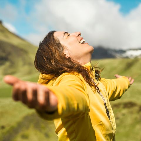 Datingtrend für Frauen: Eine Frau breitet lächelnd die Arme aus