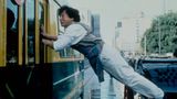 Jackie Chan hängt zwischen einem Zug und einem Auto