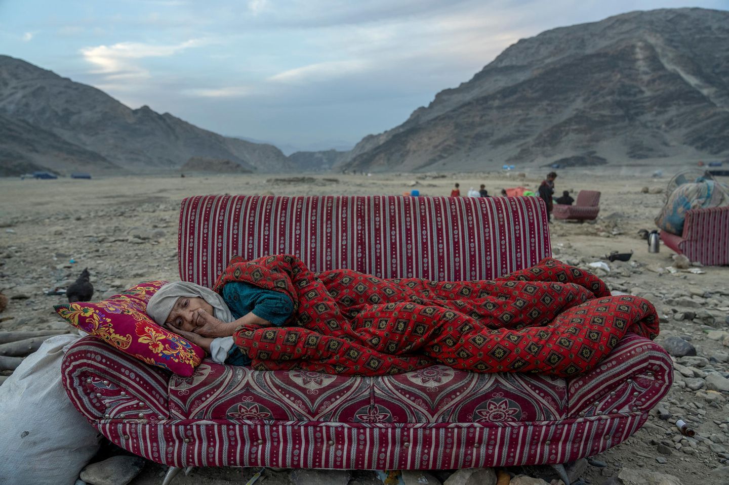 World Press Photo: Afghanische Frau auf einem Sofa in der Wüste liegend