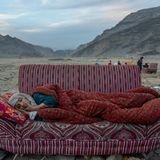World Press Photo: Afghanische Frau auf einem Sofa in der Wüste liegend
