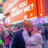 Ein Paar küsst sich nach einem Heiratsantrag am Times Square