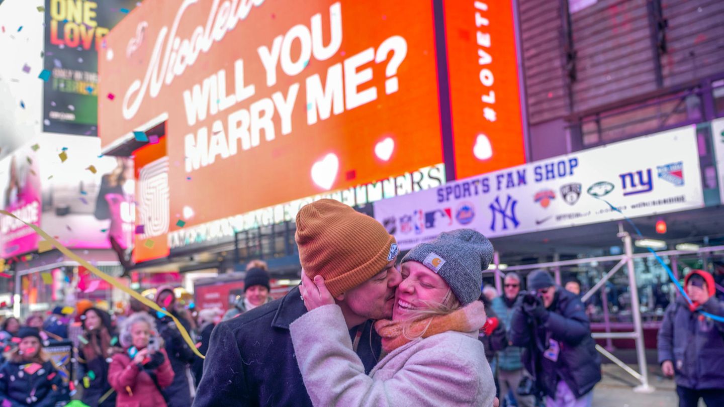 Ein Paar küsst sich nach einem Heiratsantrag am Times Square