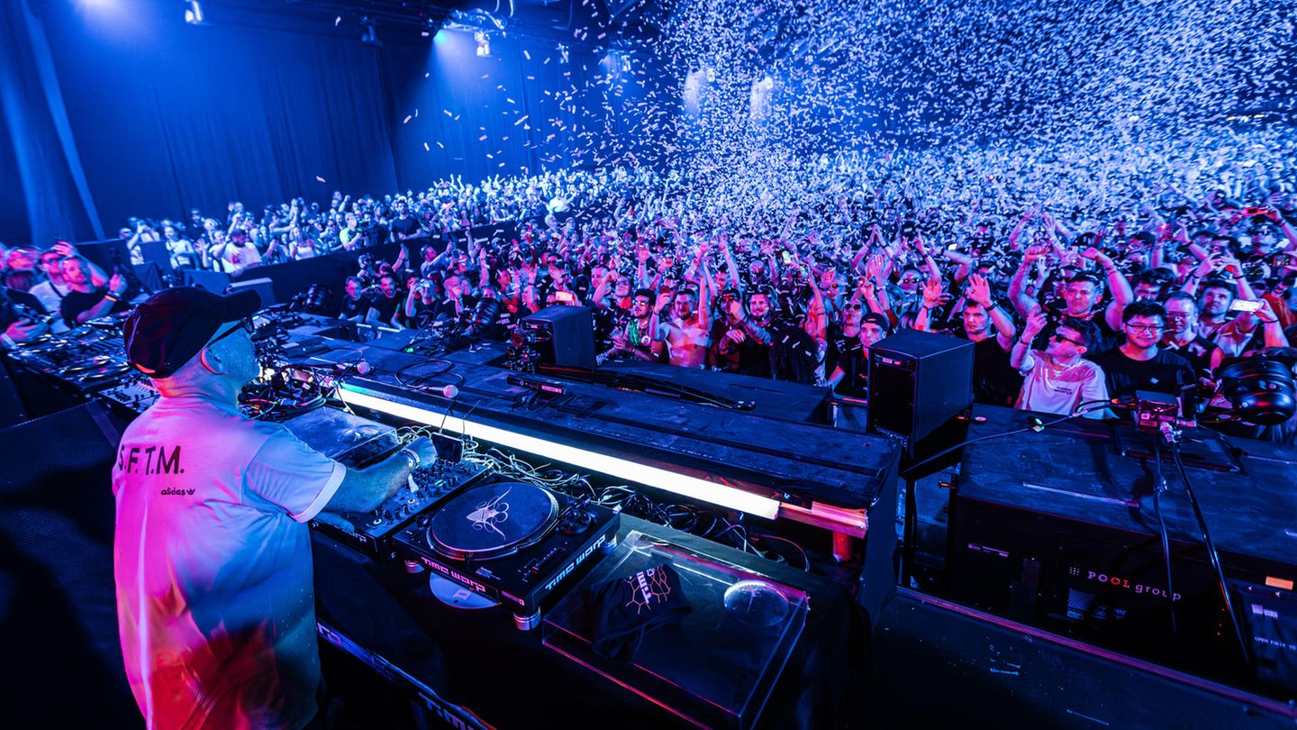 DJ Sven Väth auf der Bühne, weißes Konfetti regnet auf die Masse