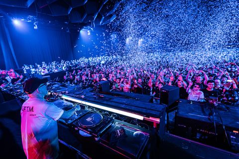 DJ Sven Väth auf der Bühne, weißes Konfetti regnet auf die Masse