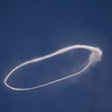 Ein Rauchkringel am blauen Himmel