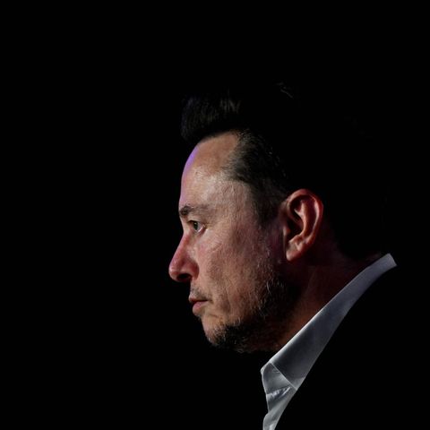 Elon Musk, vor dunklem Hintergrund, blickt nach links