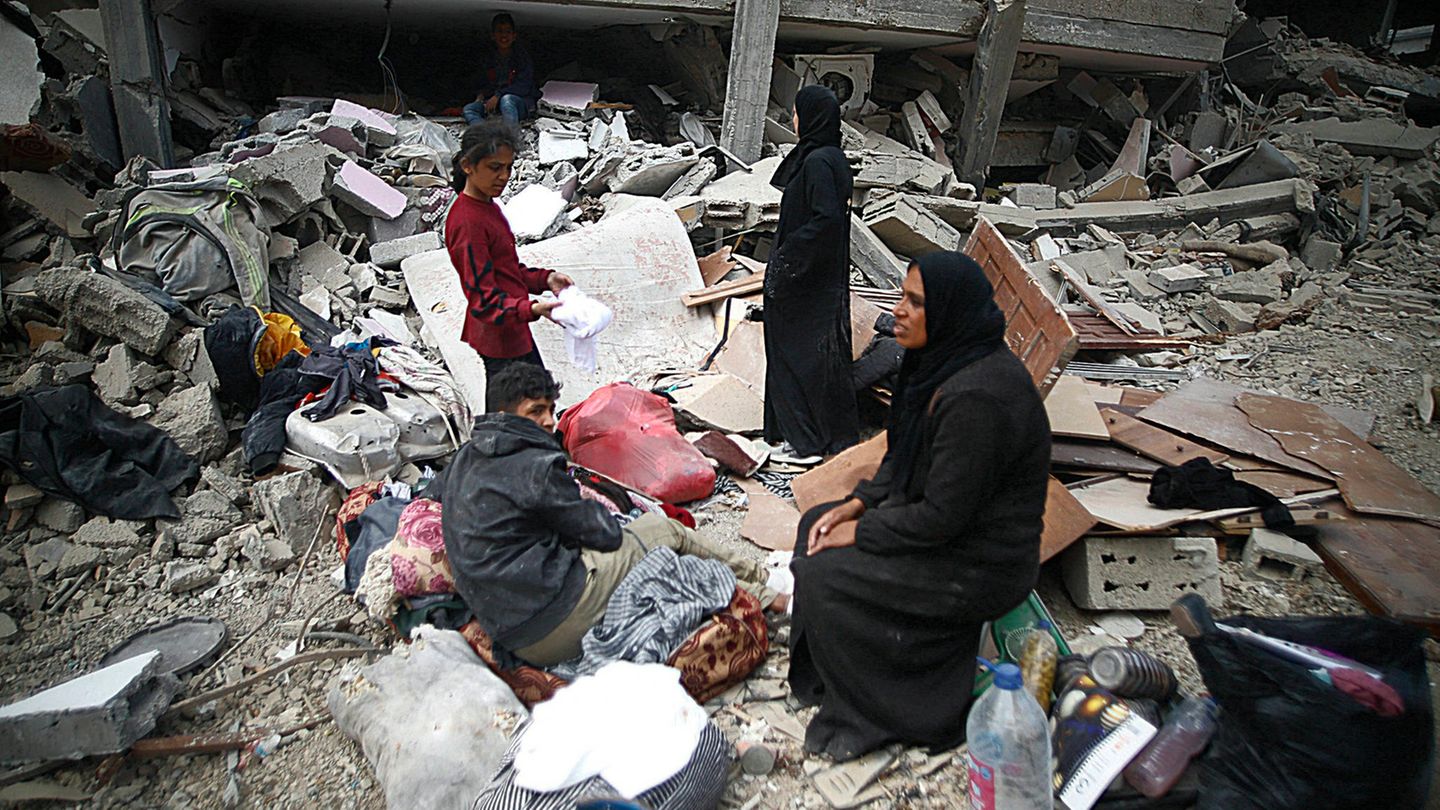 Een palästinensische Familie voor zrstörten Gebäuden in Khan Yunis.