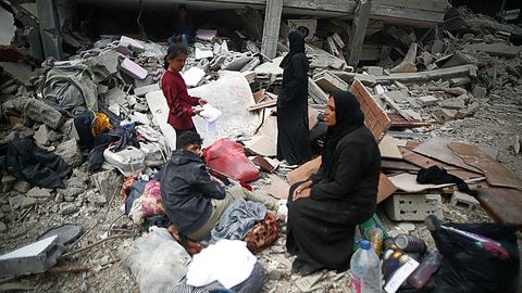 Eine palästinensische Familie vor zerstörten Gebäuden in Khan Yunis.