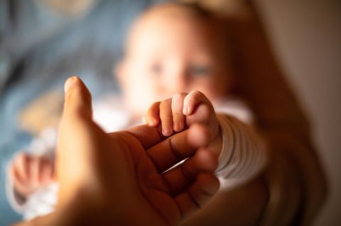 Vaterschaft: Ein Mann hält die Hand eines Babys