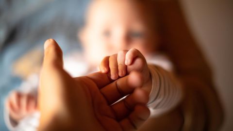Vaterschaft: Ein Mann hält die Hand eines Babys