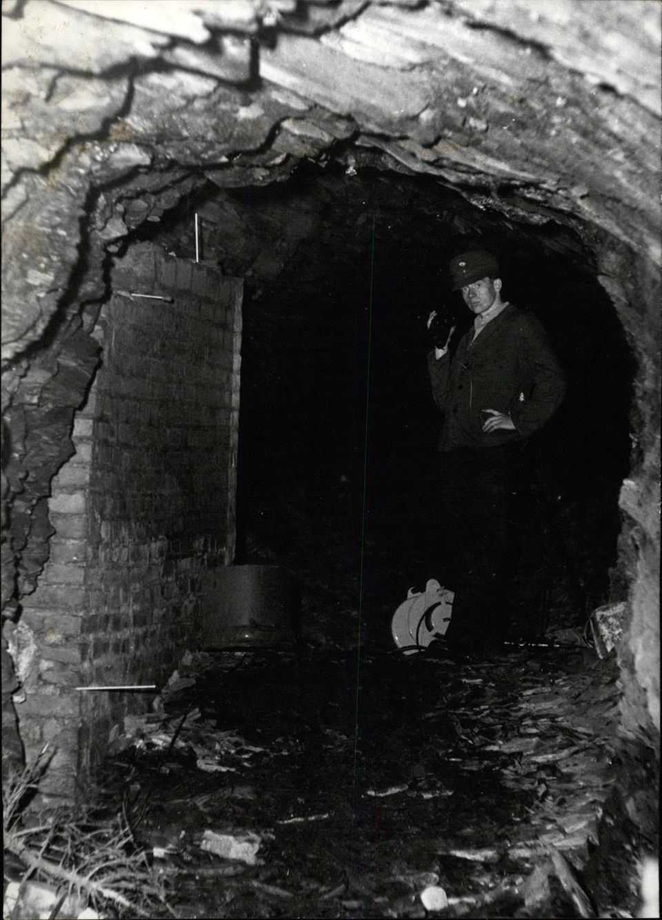Ein Polizist steht im Eingang zur Höhle, in der Jürgen Bartsch die Kinderleichen versteckt hat
