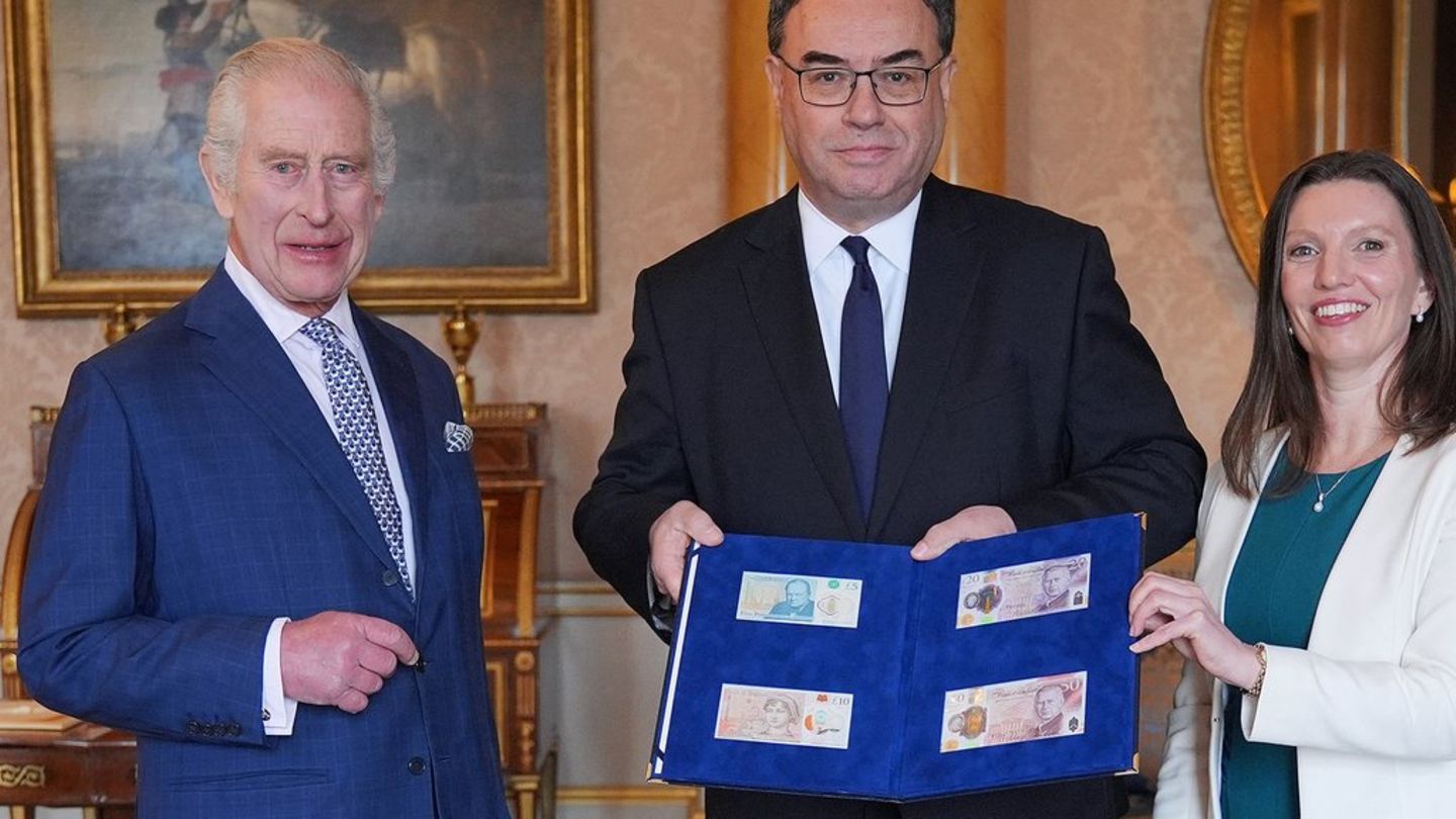 Koning Karel III.  met de gouverneur van de Bank of England, Andrew Bailey, en de nieuwe bankbiljetten.
