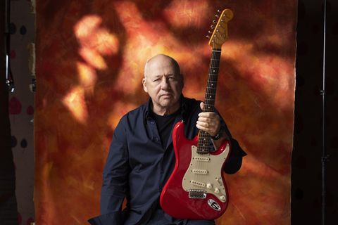 Musiker Mark Knopfler posiert mit Gitarre für sein Album One Deep River