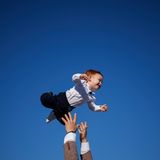 Ein muslimischer Mann wirft am Ende des Eid al Fitr-Gebets in Rumäniens Hauptstadt Bukarest zur Feier ein Baby in die Luft, das sichtlich Spaß daran hat