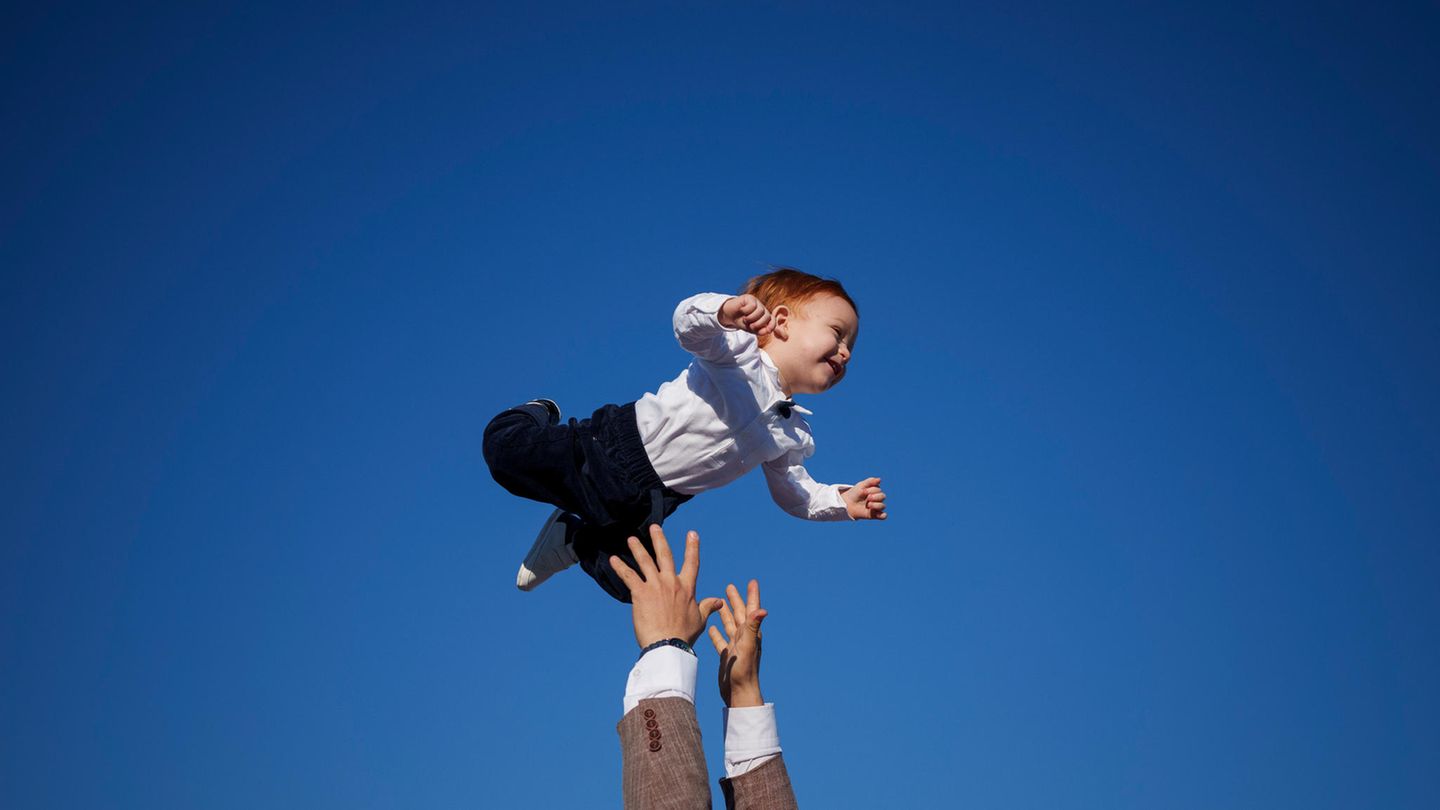 Ein muslimischer Mann wirft am Ende des Eid al Fitr-Gebets in Rumäniens Hauptstadt Bukarest zur Feier ein Baby in die Luft, das sichtlich Spaß daran hat