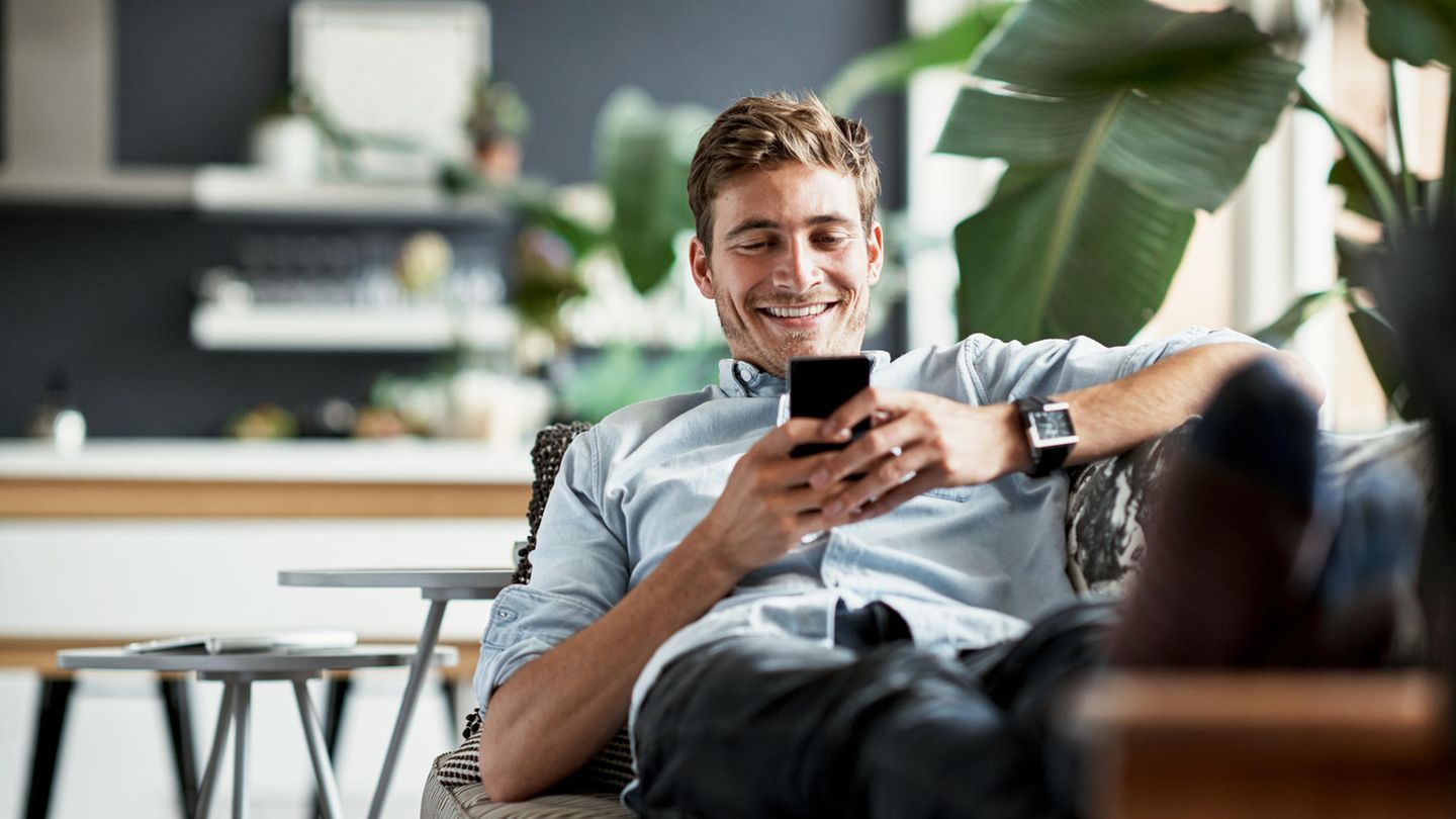 Mann liegt auf dem Sofa mit Galaxy S24 Ultra in der Hand.