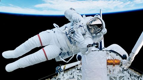 Ein Astronaut schwebt horizontal im Weltraum