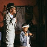 Ein älterer Mann steht mit seiner Enkelin vor dem Spiegel, beide machen sich für den Sonntagsgottestdienst schick