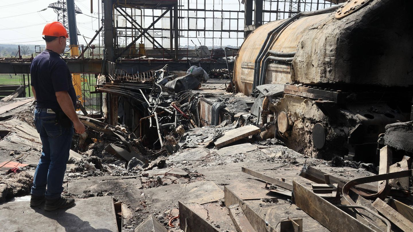Ein Arbeiter steht vor den Überresten eines Kraftwerks in der Ukraine