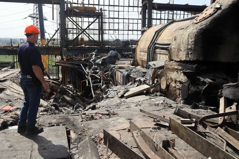 Ein Arbeiter steht vor den Überresten eines Kraftwerks in der Ukraine
