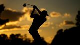 Augusta, USA. Adam Schenk macht seinen Abschlag bei der ersten Runde des Golf-US-Masters am 15. Loch. Die Silhouette im spärlichen Sonnenlicht betont eindrucksvoll Schenks Körperspannung.