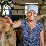 Eine Frau steht zwischen zwei Kühen im Stall