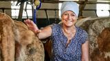 Eine Frau steht zwischen zwei Kühen im Stall
