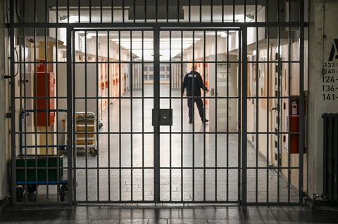 Ein Justizbeamter öffnet die Tür einer Gefängniszelle