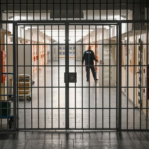 Ein Justizbeamter öffnet die Tür einer Gefängniszelle