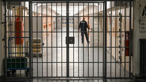 Ein Justizbeamter öffnet die Tür einer Gefängniszelle
