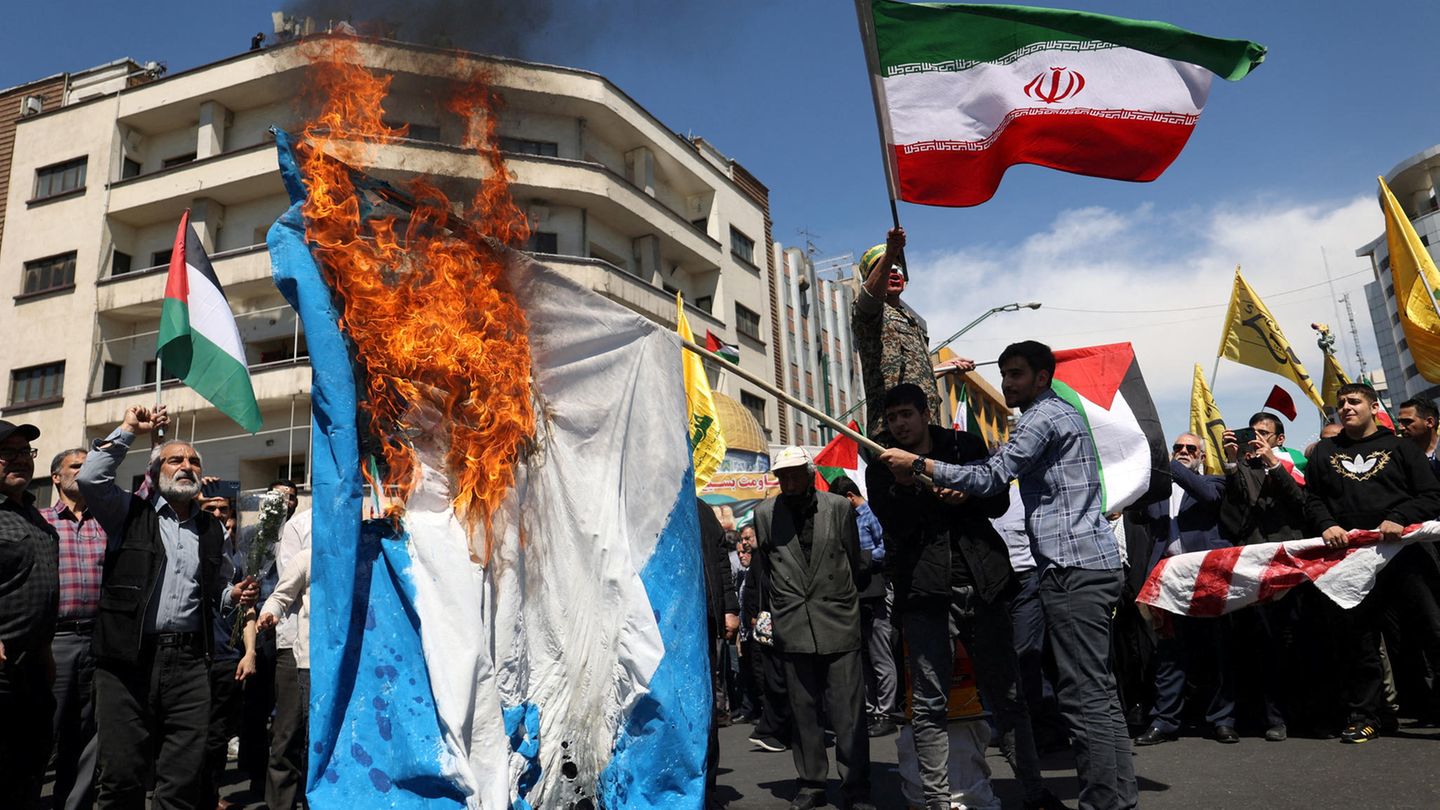 Iranische Demonstranten verbrennen eine israelische Flagge in Teheran
