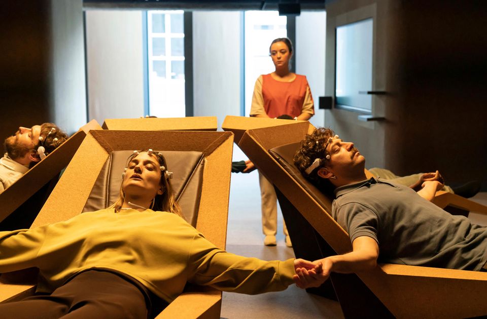 Menschen liegen auf futuristischen Liegen