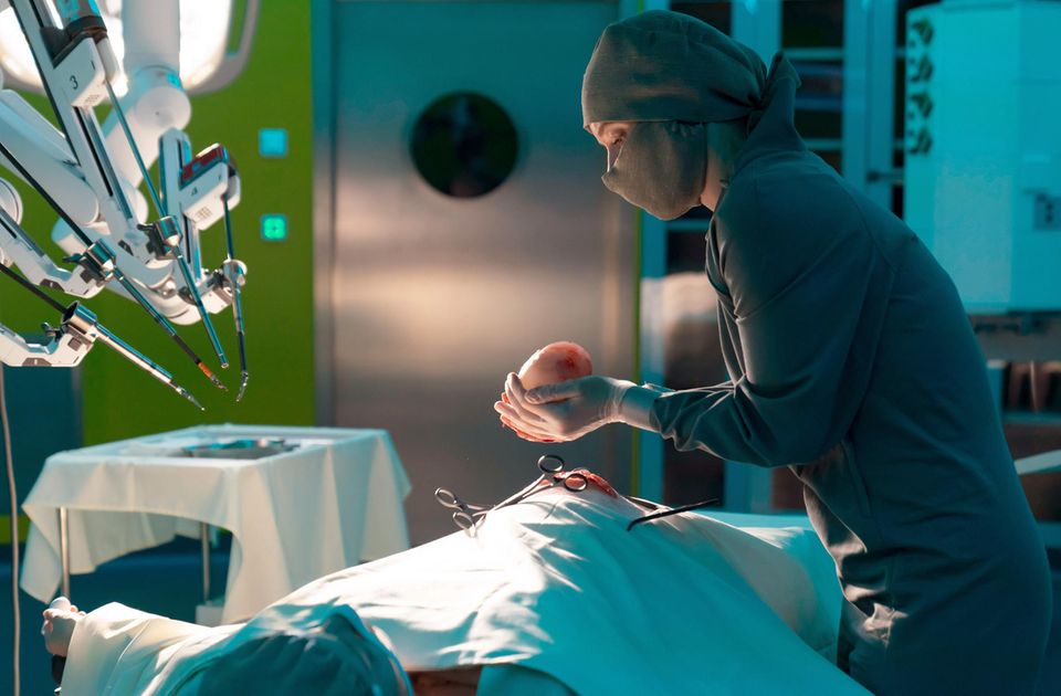 Frau im OP mit Uterus in der Hand